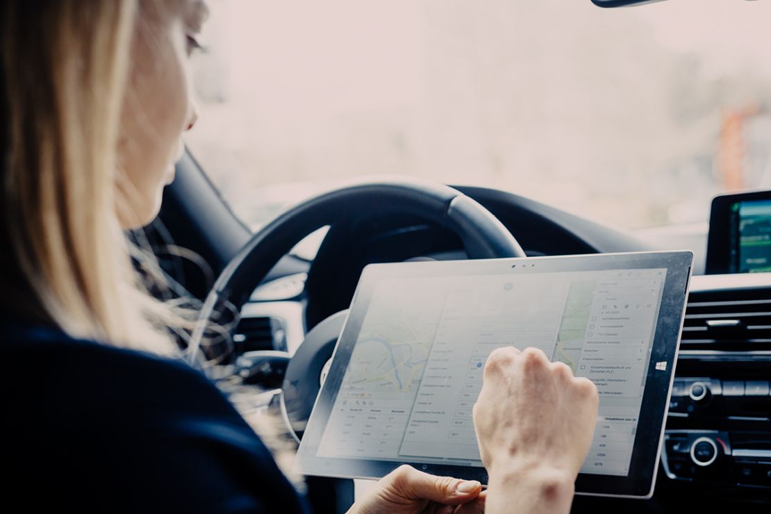Geschäftsfrau nutzt WebGIS WIGeoWeb auf Tablet nach einem Termin Geschäftsfrau nutzt WebGIS WIGeoWeb auf Tablet nach einem Termin